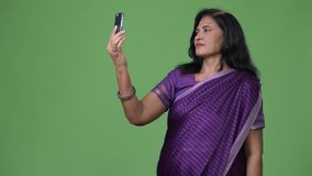 Mature happy beautiful Indian woman video calling using phone