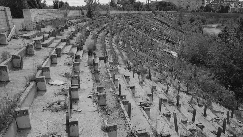 Abandoned sport stadium in Russia. Football stadium demolished by nature. Black and white with high contrast color correction version.