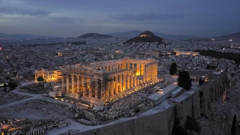 Athens Acropolis and Parthenon in evening in 4k drone shot. City center in background