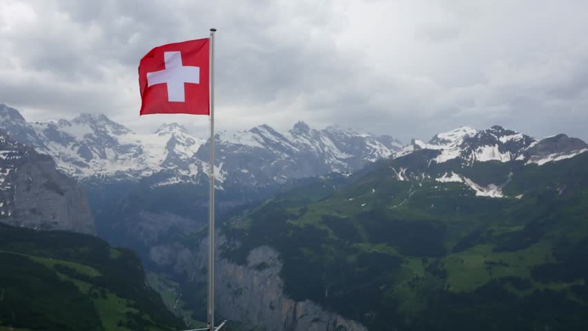 Swiss flag fluttering in the Alps