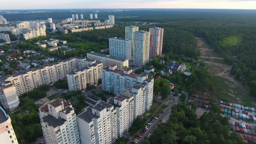 A picturesque bird`s eye view of the outskirts of Kiev with a high pine wood, a straight highway and numerous small houses in summer