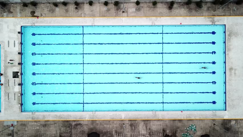 Young men swimming in a blue swimming pool, aerial drone footage | Shutterstock HD Video #1012371539
