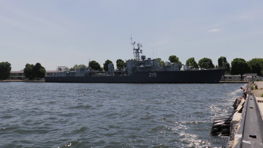 Navy ship docked in a harbor during the day. Military boat floating on water during the day time. 