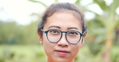 Close up asian girl portrait face.Have a smiley face with wear glasses and nature background 
