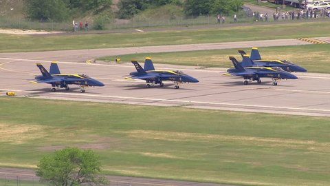Washington DC - Circa 2018: Blue Angels F18 fight jet airplanes take off from airport runway in formation. Smoke contrails escape from engine