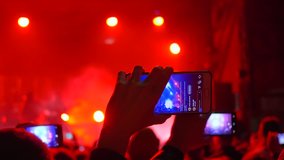 modern technologies, crowd of admirers with telephone in hands enjoy rock show on vivid stage