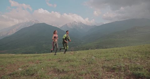 young active couple exercising in mountains in morning 4k