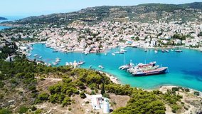 Aerial drone bird's eye view video of vegitated area of Kouzounas with Greek Navy lighthouse and small port/shipyard, island of Spetses, Saronic gulf, Greece