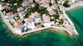 Aerial drone bird's eye view video of picturesque neoclassic houses in historic and traditional island of Spetses with emerald clear waters, Saronic Gulf, Greece