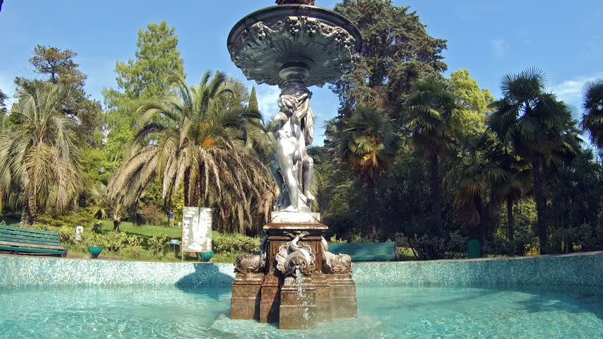 Fountain with angels memorial in pool near palms park
