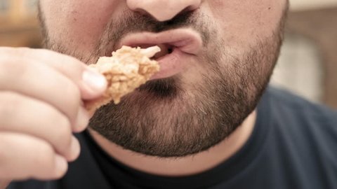 Fat man eats chicken nuggets, harmful and tasty fast food, close up