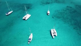 Aerial drone video of sailboats and yachts docked in tropical caribbean emerald clear waters
