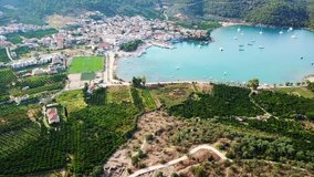 Aerial drone bird's eye view video of iconic small ancient theater and Acropolis of Epidavros in vegitated seaside village of Old Epidavros, Argolida, Peloponnese, Greece