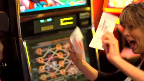 older caucasian woman plays slot machine and wins