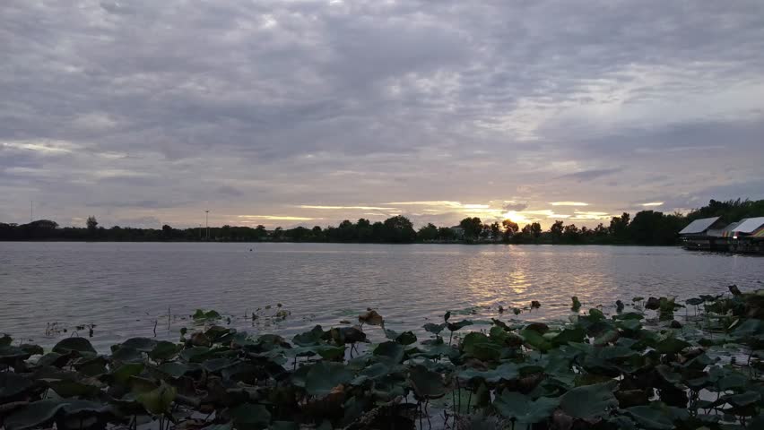 view evening over the lake, many clouds slow moving with colorful of sun shine with reflex on the water, sunset at Krajub reservoir, Banpong, Ratchaburi, Thailand