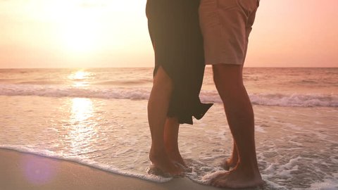 View of the legs: couple stands on the shore and kiss