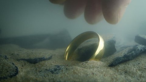 Someone Picks Up Gold Ring Underwater
