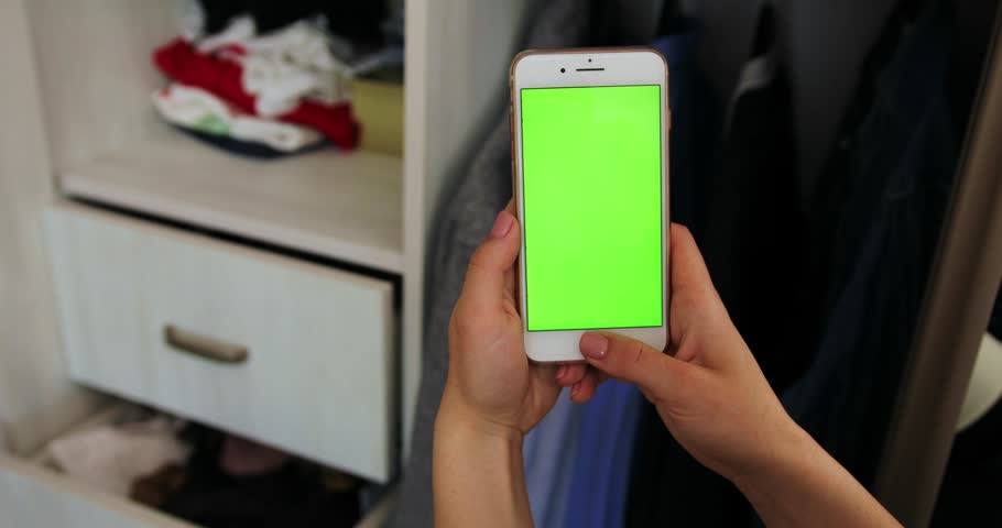Tokio, Japan - April 7, 2018. Close up woman hand holding use smart phone with vertical green screen in background of wardrobe with clothes preparation departure cell phone concept leaving business | Shutterstock HD Video #1012424897