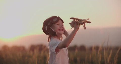 close-up shot of happy boy with toy airplane in wheat field running. dream, childhood, memories concept.Slow motion, sunset time.