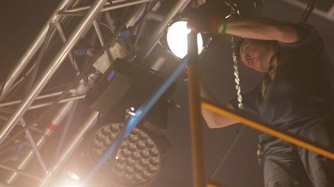 Moscow, Russia - December 17,2017: Handheld shot of male stage worker setting up the lights.