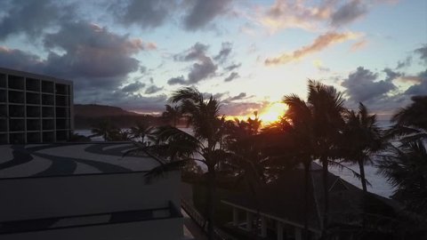 4k drone shot of turtle bay resort hawaii sunset over ocean waves and palm trees