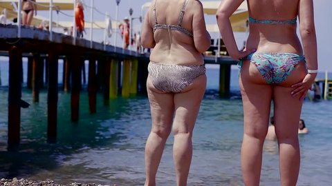 two women with obesity and cellulite are on the beach overlooking the sea. diet and weight loss concepts