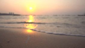 Blurred defocused video clip of beautiful background clean beach in yellow sunset. Royalty high-quality free stock footage of seawater on the beach with sand and sunshine in summer