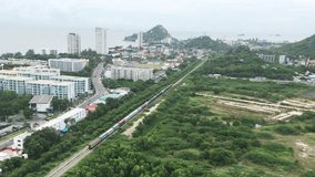 Footage video  Aerial view clip of long freight train passes through Hua Hin famous resort town in southern Thailand.