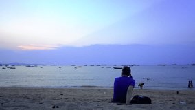 Alone man relax on the beach. Royalty high quality free stock video clip of a man sitting on the beach, listen to music and see the sunset. The sea is a great place to travel in the summer