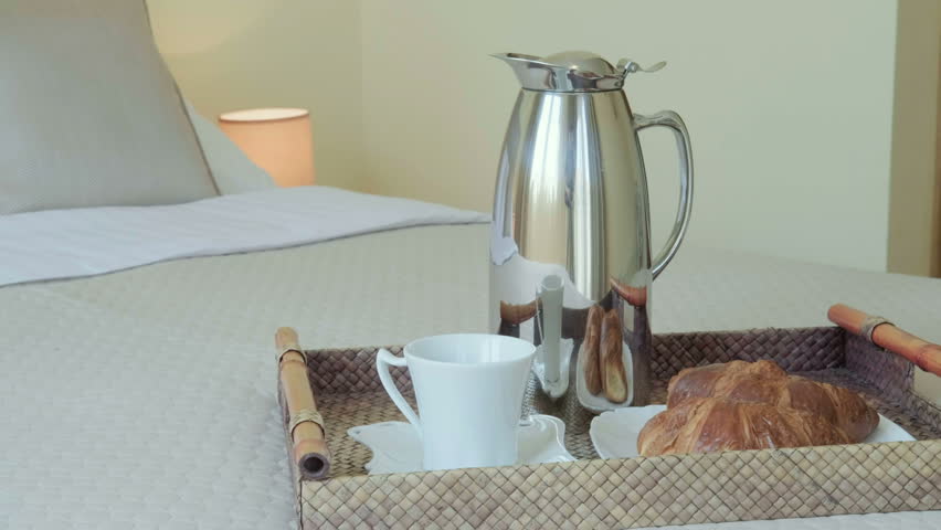 Tray with tasty breakfast on white bed at hotel room with sea view. 4k