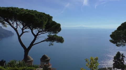Spectacular Amalfi coast scenery in Italy, view from above of blue Tyrrhenian sea and sky behind pine tree and old church belfry top