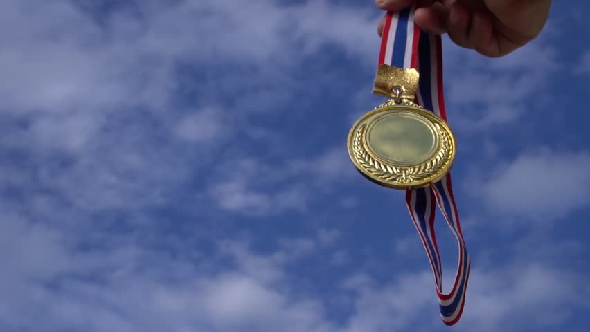 Winners Champion in success award concept : Businessman hands raised holding gold medals with ribbon against blue sky background to show success in sport or business, Slow motion video | Shutterstock HD Video #1012449293