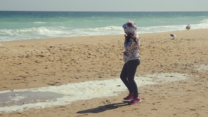 Girl playing with her feet in spring sand. Slow motion