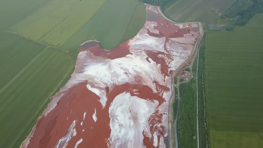 Aerial view of a reservoir full of red toxic sludge 