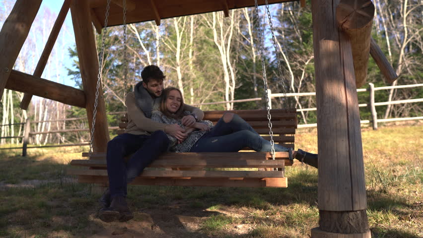 Young couple leaning on a porch swing
