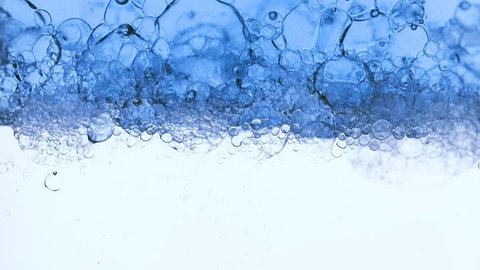 Oxygen bubbles in clear blue water, close-up. Mineral water. Water enriched with oxygen. Splashes of water.