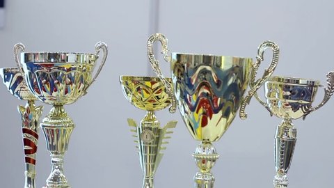 Many shiny gold trophies in a rows