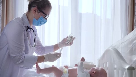 health care, doctor in mask with syringe prepares baby for treatment in hospital under sterile conditions - Βίντεο στοκ