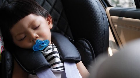 cute child sleeping in car seat