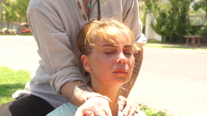 Face young woman getting neck and shoulders massage for treatment pain and muscle tension oudoor. Close up neck and shoulders massage for recovery and relaxation. Healty lifestyle concept