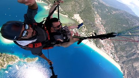 Paragliding oludeniz flying turkey Friday, June 15 - 2018 / Paragliding in the sky. Paraglider tandem flying over the sea with blue water, beach and mountains in sunrise. Aerial view of paraglider.