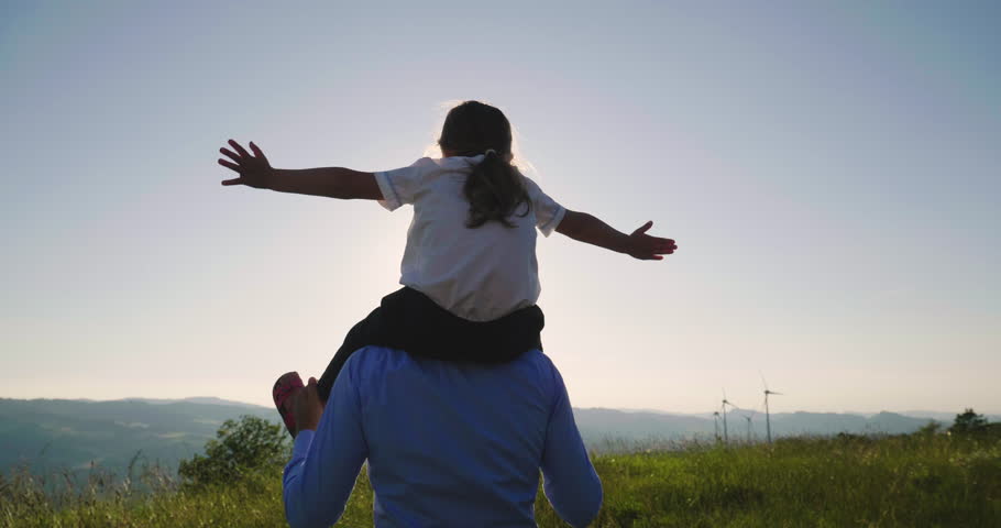 A father engineer, holds his daughter in his arms and runs between the wind turbines with great freedom. Concept of: environmental engineering, renewable energy and love for nature and for the family Royalty-Free Stock Footage #1012504949