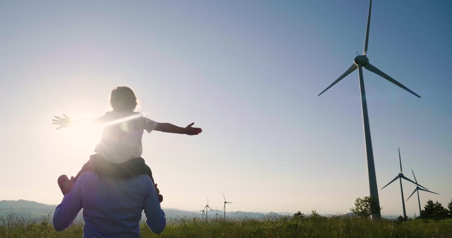 A father engineer, holds his daughter in his arms and runs between the wind turbines with great freedom. Concept of: environmental engineering, renewable energy and love for nature and for the family Royalty-Free Stock Footage #1012504952