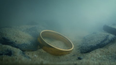 Gold Ring Drops Onto Rocks Underwater