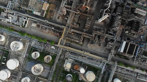 Aerial top down view over oil refinery or chemical factory and power plant with many storage tanks and pipelines. Shot with 4K UHD resolution drone.