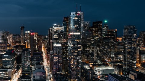 Toronto city traffic driving through the downtown urban core. Modern, urban and futuristic office and condo building skyscrapers in the background brightly lit up at night.  – Video có sẵn