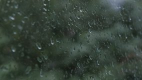 Clip of raindrops on window, water dripping over glass