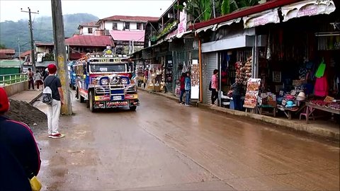 BAGUIO CITY, PHILIPPINES - JUNE 7, 2018: Colorful passenger jeepneys passing by a street.