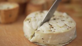 Cutting of baked Camembert with garlic. Camembert with garlic, oliv oil, pepper and croutons.