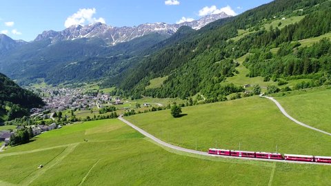 Bernina Express on the railway in Val Poschiavo. Summer season, aerial view.